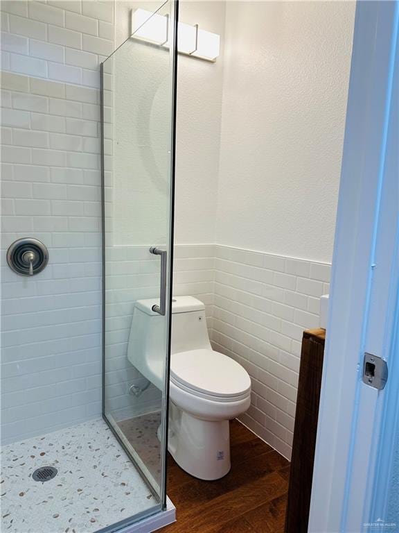 1523 Evergreen Ave, Mission, TX 78572 - bathroom featuring a shower stall, wood finished floors, tile walls, and wainscoting