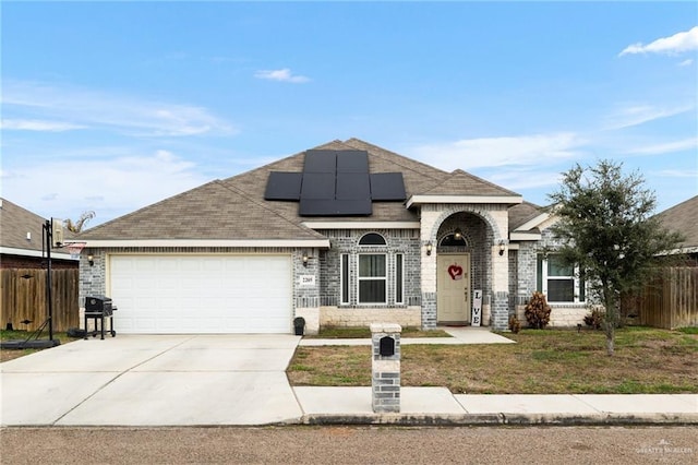 view of front of property with a garage and solar panels