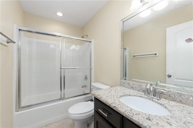 full bathroom featuring tile patterned floors, vanity, toilet, and bath / shower combo with glass door