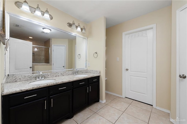 bathroom with tile patterned flooring, vanity, and tiled shower