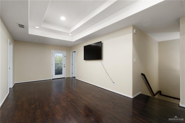 spare room featuring dark hardwood / wood-style floors and a raised ceiling