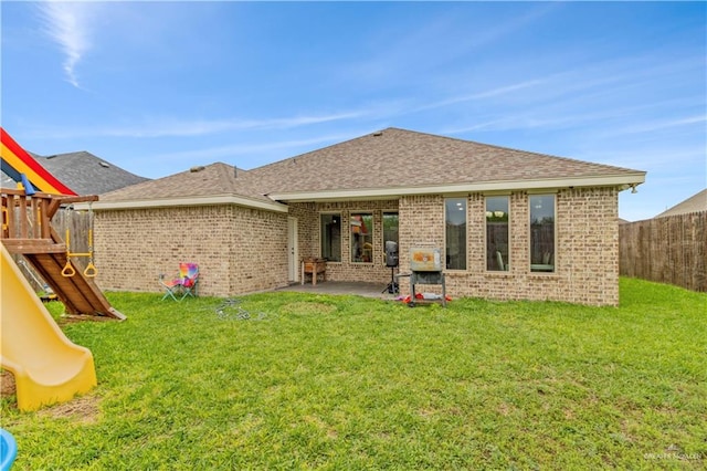 back of property with a playground, a yard, and a patio