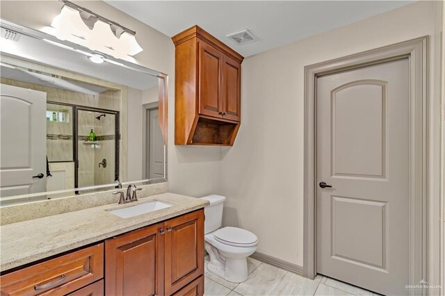 bathroom featuring tile patterned flooring, vanity, toilet, and walk in shower