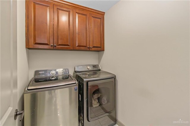 laundry room featuring washer and dryer and cabinets