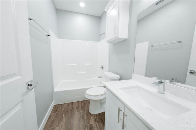 2605 Sage Dr, Weslaco, TX 78596 - bathroom with shower / bathing tub combination, toilet, vanity, wood finished floors, and baseboards