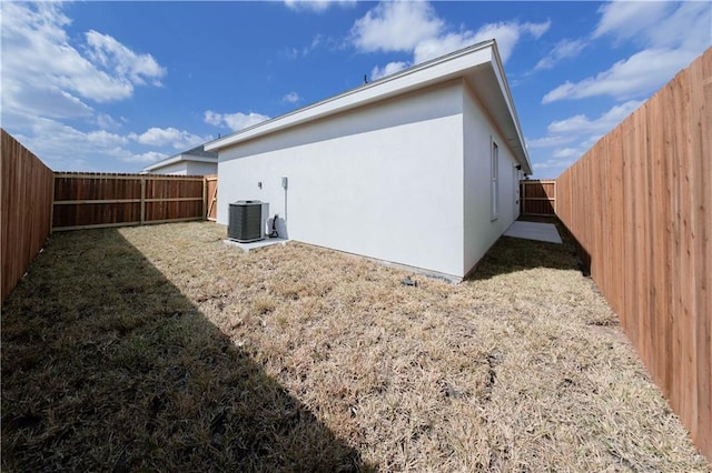 2605 Sage Dr, Weslaco, TX 78596 - back of house with central AC, a yard, a fenced backyard, and stucco siding