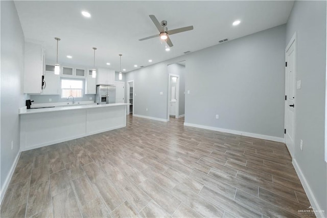 2605 Sage Dr, Weslaco, TX 78596 - unfurnished living room with ceiling fan, recessed lighting, a sink, baseboards, and light wood-type flooring