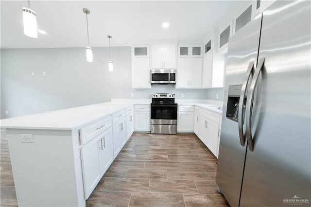 2605 Sage Dr, Weslaco, TX 78596 - kitchen with stainless steel appliances, light countertops, hanging light fixtures, glass insert cabinets, and white cabinets