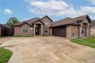 view of front of property with stone siding, an attached garage, and driveway