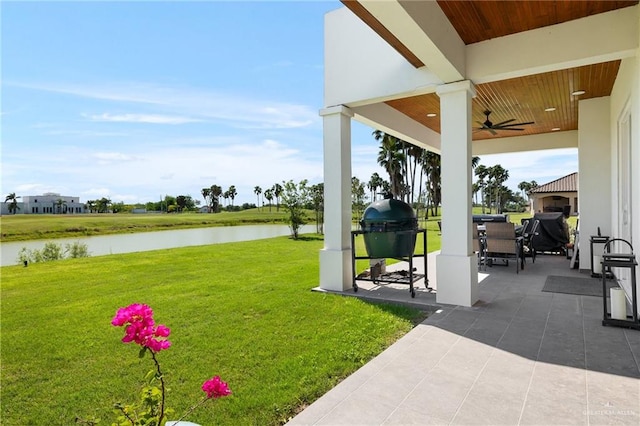 view of yard featuring ceiling fan, a water view, and a patio