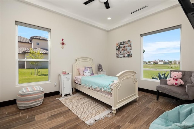 bedroom with dark hardwood / wood-style flooring, multiple windows, and ceiling fan