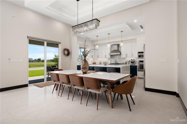 tiled dining room with a raised ceiling