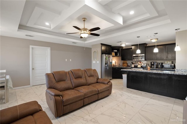 living room with ceiling fan and a tray ceiling