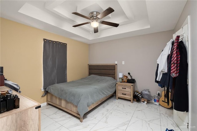 bedroom featuring a tray ceiling and ceiling fan