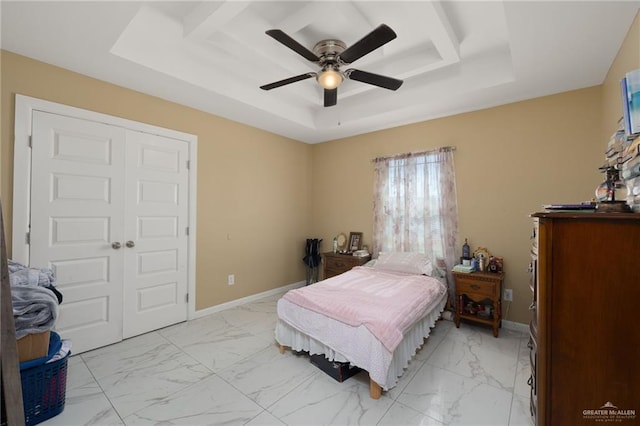 bedroom featuring a closet, a raised ceiling, and ceiling fan