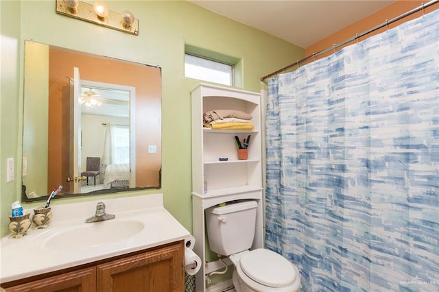 bathroom with walk in shower, ceiling fan, vanity, and toilet