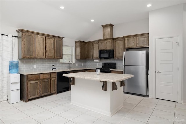 kitchen with light countertops, a kitchen island, a sink, and black appliances