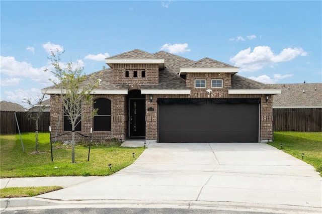 view of front of house with an attached garage, brick siding, fence, and a front lawn