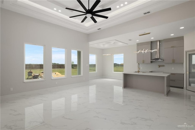 unfurnished living room featuring a raised ceiling, a ceiling fan, visible vents, and recessed lighting