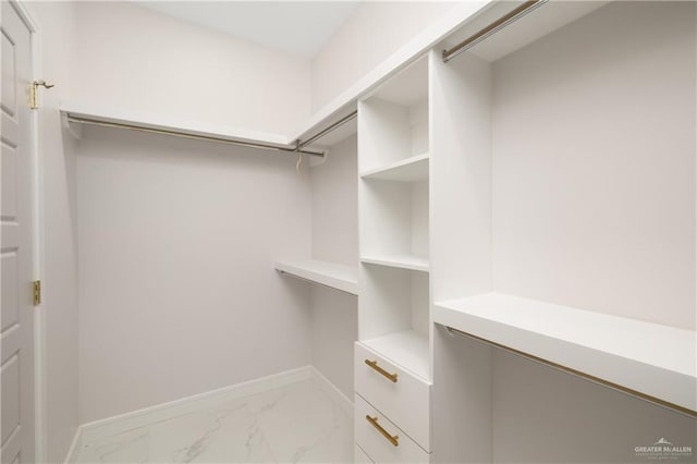 walk in closet with marble finish floor