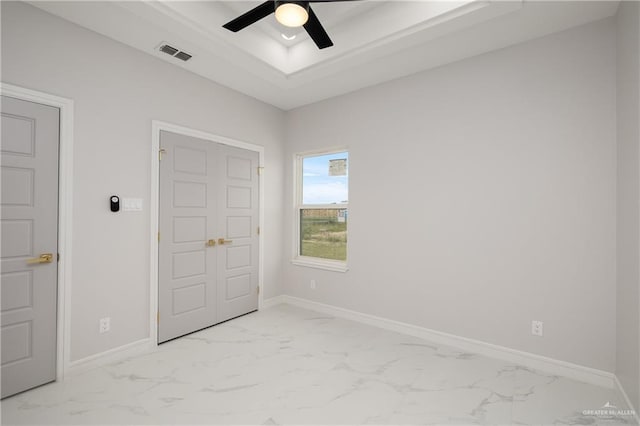 unfurnished bedroom with marble finish floor, visible vents, and a raised ceiling