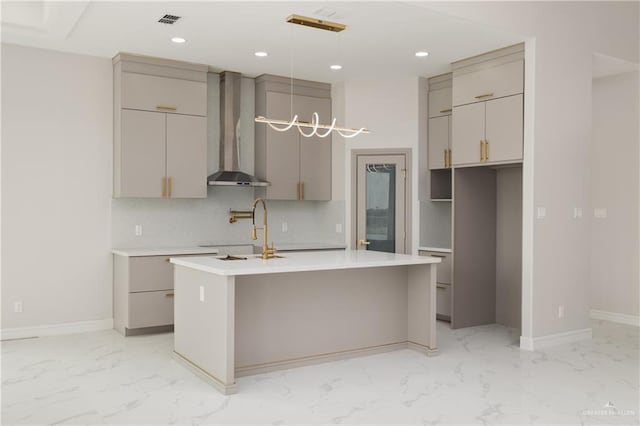 kitchen with light countertops, wall chimney range hood, marble finish floor, and gray cabinets