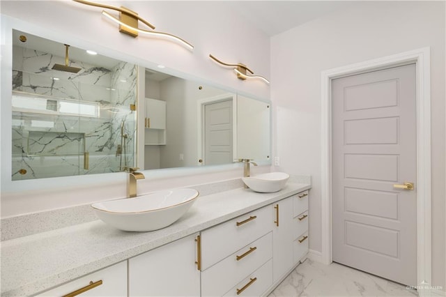 bathroom with a marble finish shower, a sink, marble finish floor, and double vanity