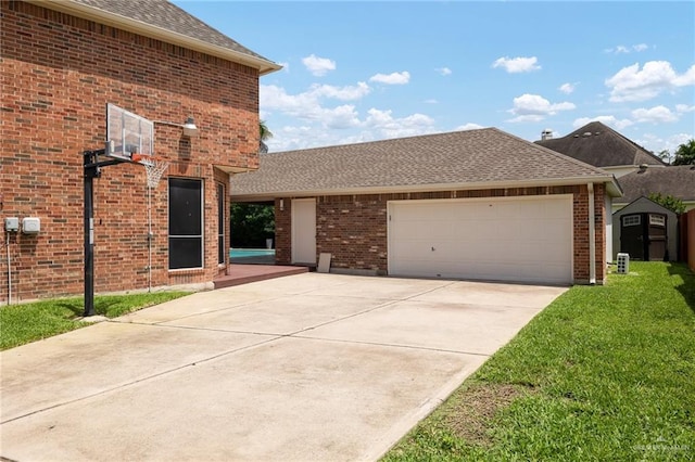 front facade featuring a front lawn, a garage, and a storage shed