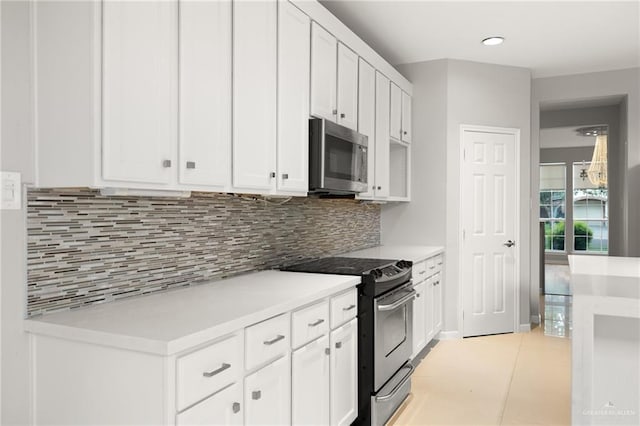 kitchen featuring backsplash, white cabinets, light tile patterned floors, and appliances with stainless steel finishes