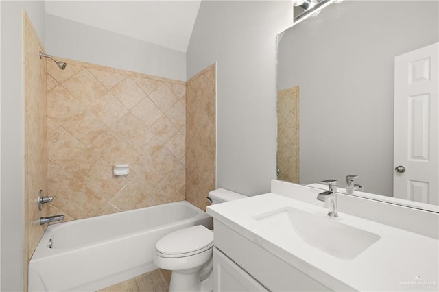 full bathroom featuring hardwood / wood-style floors, vaulted ceiling, toilet, vanity, and tiled shower / bath