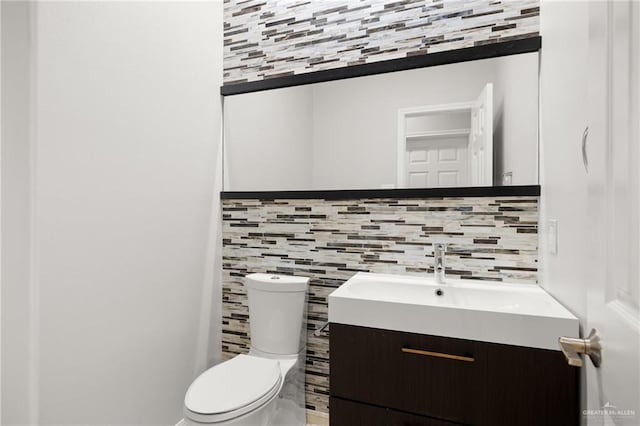 bathroom with decorative backsplash, vanity, and toilet