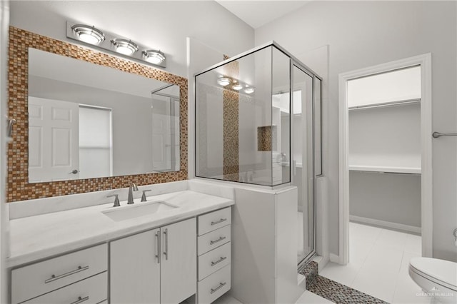 bathroom with tile patterned floors, vanity, toilet, and a shower with shower door