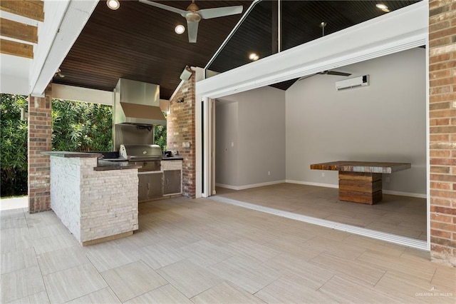 view of patio / terrace with ceiling fan, area for grilling, exterior kitchen, and a wall unit AC