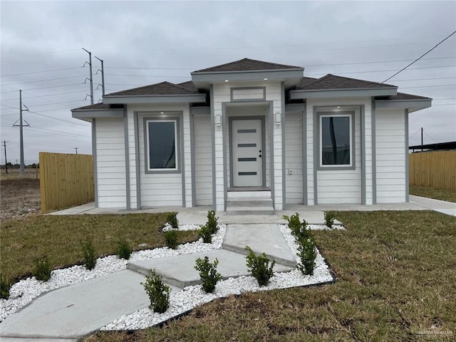 prairie-style house with a front yard and fence