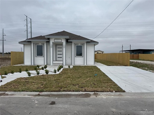 view of front of home with a front lawn and fence