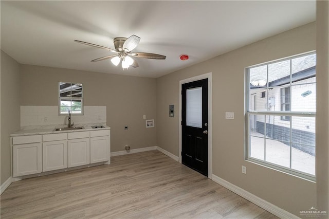 washroom with electric dryer hookup, cabinets, sink, washer hookup, and a wealth of natural light