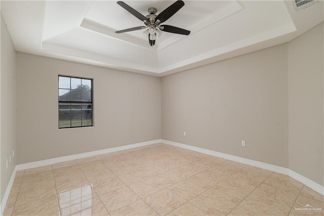 unfurnished room with light tile patterned floors, a raised ceiling, and ceiling fan