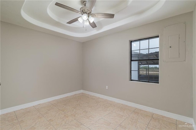 unfurnished room with electric panel, a tray ceiling, ceiling fan, and light tile patterned flooring