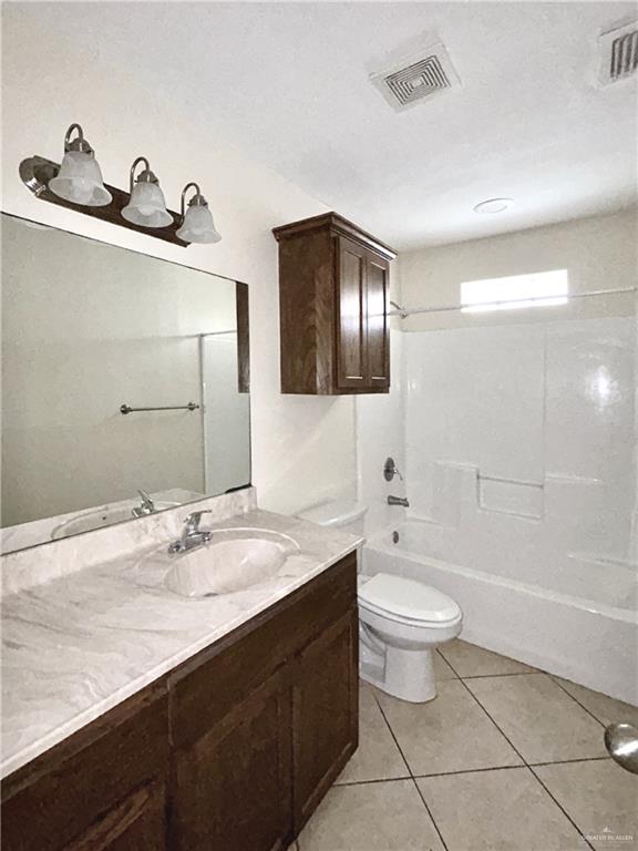 full bathroom with washtub / shower combination, vanity, tile patterned floors, and toilet