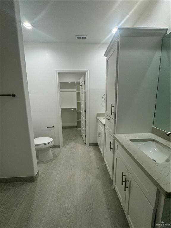 bathroom featuring hardwood / wood-style flooring, vanity, and toilet