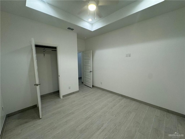 unfurnished bedroom with ceiling fan, light hardwood / wood-style floors, and a closet