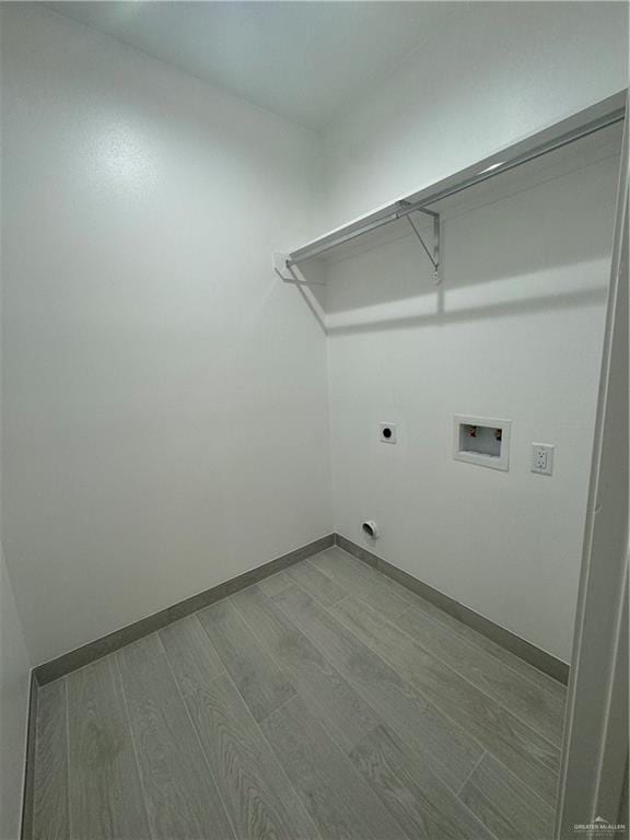 clothes washing area featuring hardwood / wood-style flooring, electric dryer hookup, and hookup for a washing machine