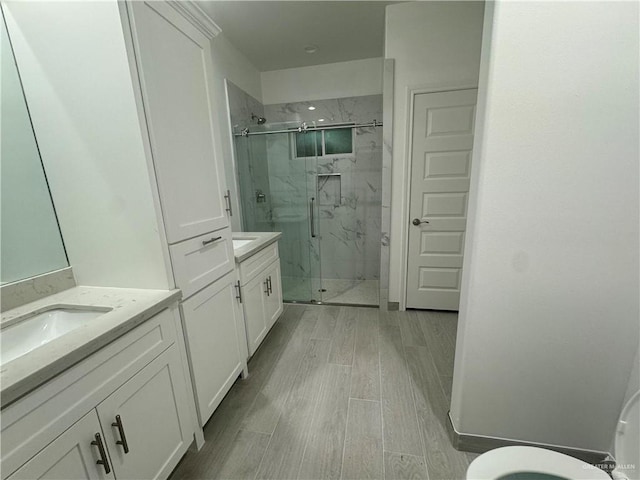 bathroom with vanity, wood-type flooring, and a shower with shower door