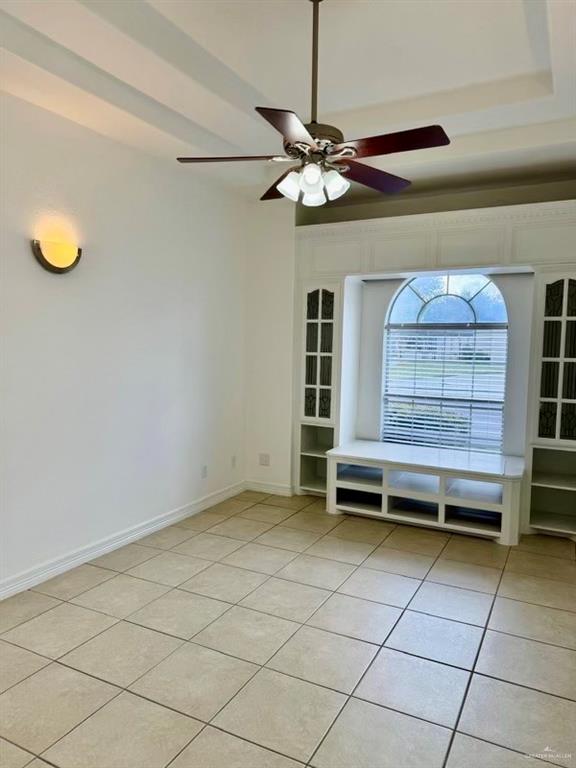 empty room featuring light tile patterned floors and ceiling fan