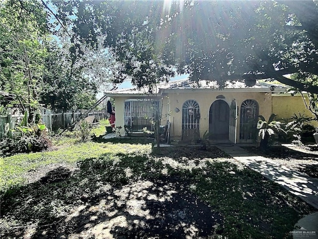 exterior space featuring fence and stucco siding