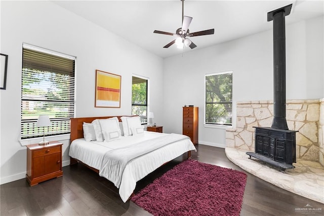 136 W Evergreen St, Boerne, TX 78006 - bedroom with a wood stove, dark wood-style flooring, and a ceiling fan