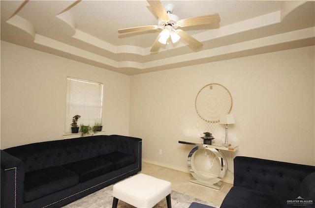 living room featuring ceiling fan and a tray ceiling