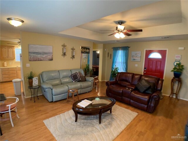 14022 Whitewing Ln, Lyford, TX 78569 - living room with a ceiling fan, light wood-style flooring, and a tray ceiling