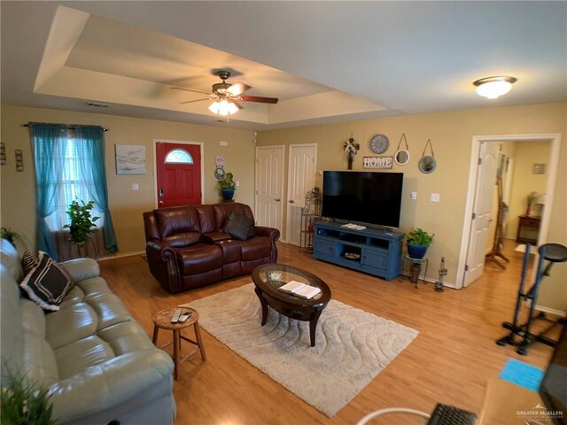 14022 Whitewing Ln, Lyford, TX 78569 - living room with a tray ceiling, light wood finished floors, baseboards, and a ceiling fan