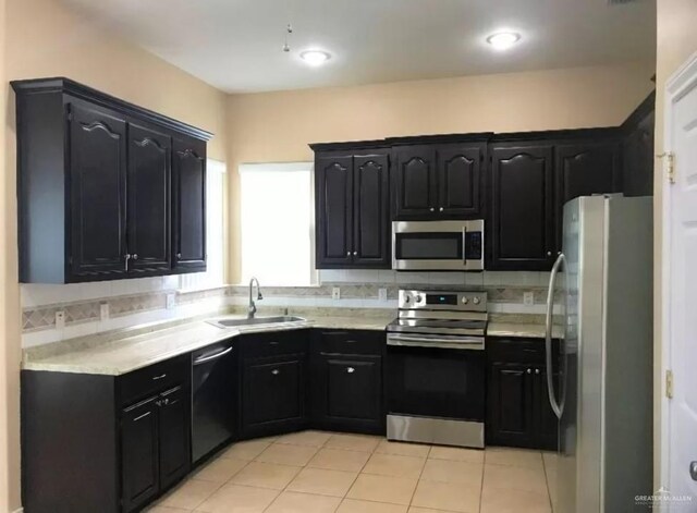 kitchen featuring light tile patterned flooring, backsplash, stainless steel appliances, and sink